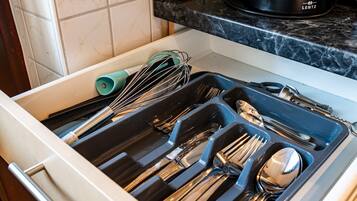 Un cajón de cocina con utensilios y una cafetera LENTZ sobre la encimera.