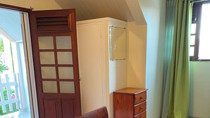 A bedroom with a bed, a wardrobe, a mirror, and a door leading to an outdoor area. - Sainte-Anne | Pointe Marin beach 400m away! (Sainte-Anne)