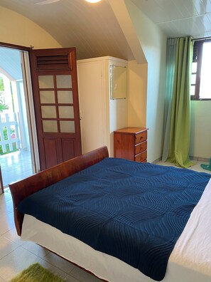 A bedroom with a bed, a wardrobe, a mirror, and a door leading to an outdoor area. - Sainte-Anne | Pointe Marin beach 400m away! (Sainte-Anne)