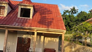 A house with a red roof, a front porch with a bench, and a tiled walkway. - Sainte-Anne | Pointe Marin beach 400m away! (Sainte-Anne)