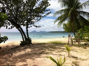 A beach with clear water, palm trees, and distant mountains. - Sainte-Anne | Pointe Marin beach 400m away! (Sainte-Anne)