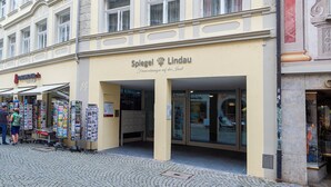 Un edificio con un cartello che riporta 'Spiegel Lindau' e una vetrina che espone diversi articoli.