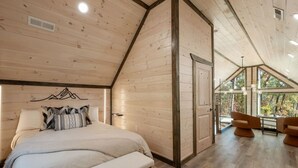Un dormitorio con una cama, un banco, un escritorio y una silla.