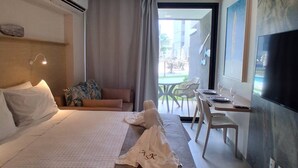 Ein Hotelzimmer mit Bett, Schreibtisch, Stuhl, Fernseher und einem Balkon mit Blick.