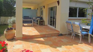 A patio with a table and chairs, a potted plant, and a sliding glass door. - Family house 5 minutes from the beach (Calella de Palafrugell)