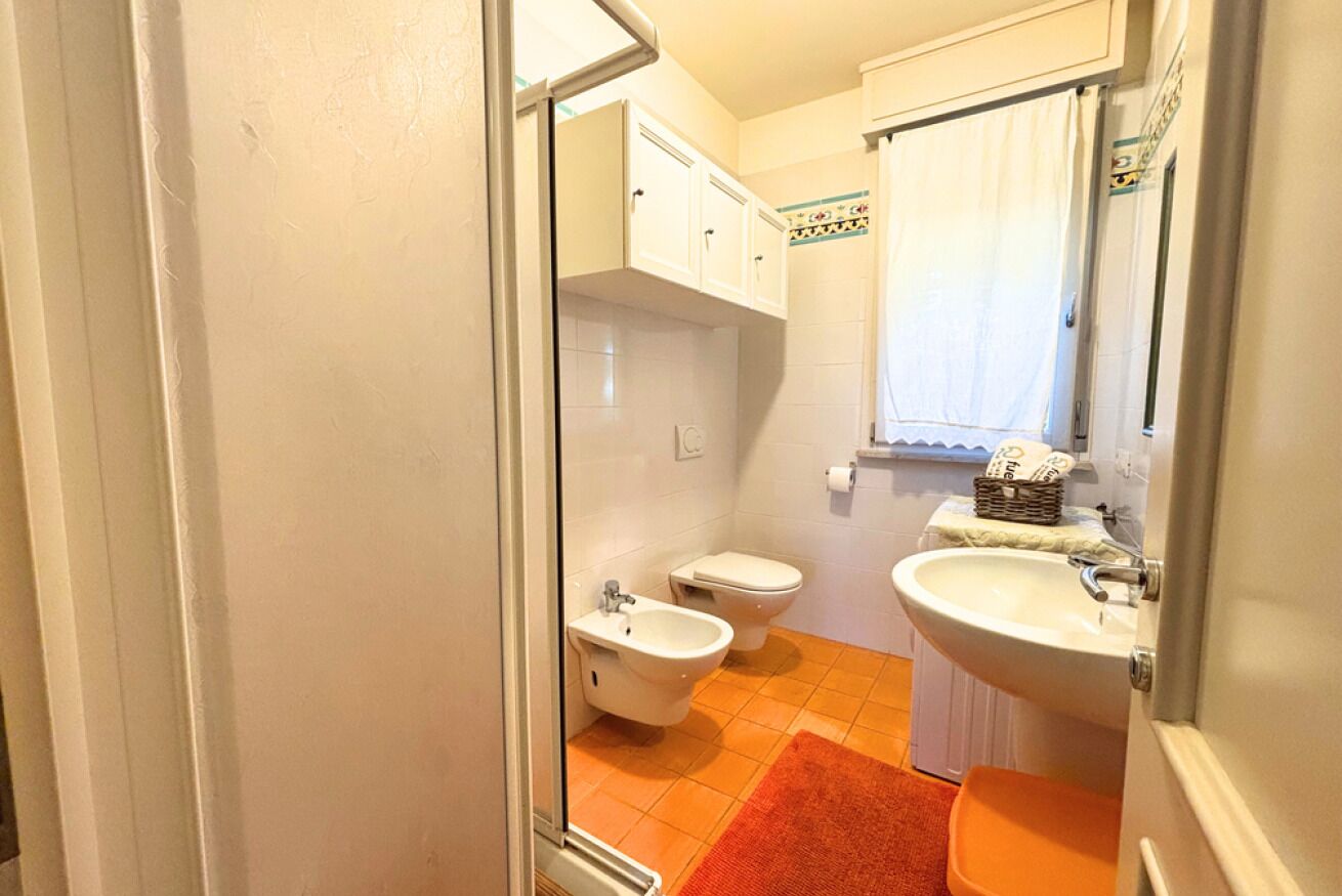 Ein Badezimmer mit einer Bidet-Einrichtung, Toilette und Waschbecken.