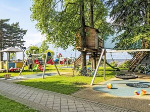 A playground with swings, slides, and a treehouse. - Nicotina by Interhome (Dervio)