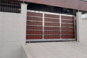 Ein geschlossenes Garagentor mit Metallrahmen, einer Betonwand und einem mit Fliesen belegten Boden.