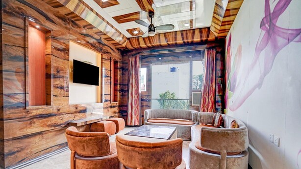 Uma sala de estar moderna com teto de madeira, televisão de tela plana e uma grande janela com cortinas.