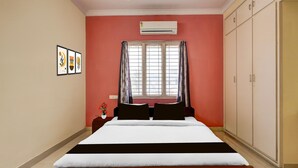 A bedroom with a bed, an air conditioner, a window with curtains, and a wardrobe. - Premiumcollection O Bhanugudi Junction (Kakinada)