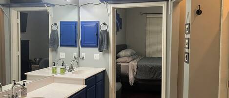 A bathroom with two sinks, a mirror, and a vanity.