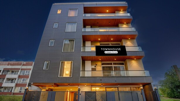 Monikerroksinen rakennus, jonka kyltissä lukee: ”TOWNHOUSE & Company Services”.