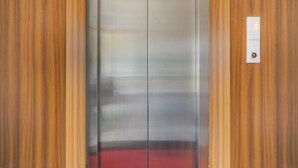 Een lift met een metalen bekleding en een rode loper aan de onderkant.