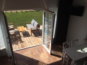 A room with a sliding glass door leading to an outdoor patio with a sofa, chairs, and a table. - Holiday Cottages by the sea in an Oasis of Peace (Smoldzino)