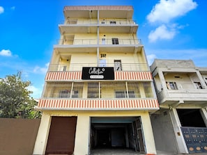 A multi-story building with a sign indicating it is a company-serviced collection point.