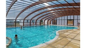 Piscina interior com estrutura de teto curvada.