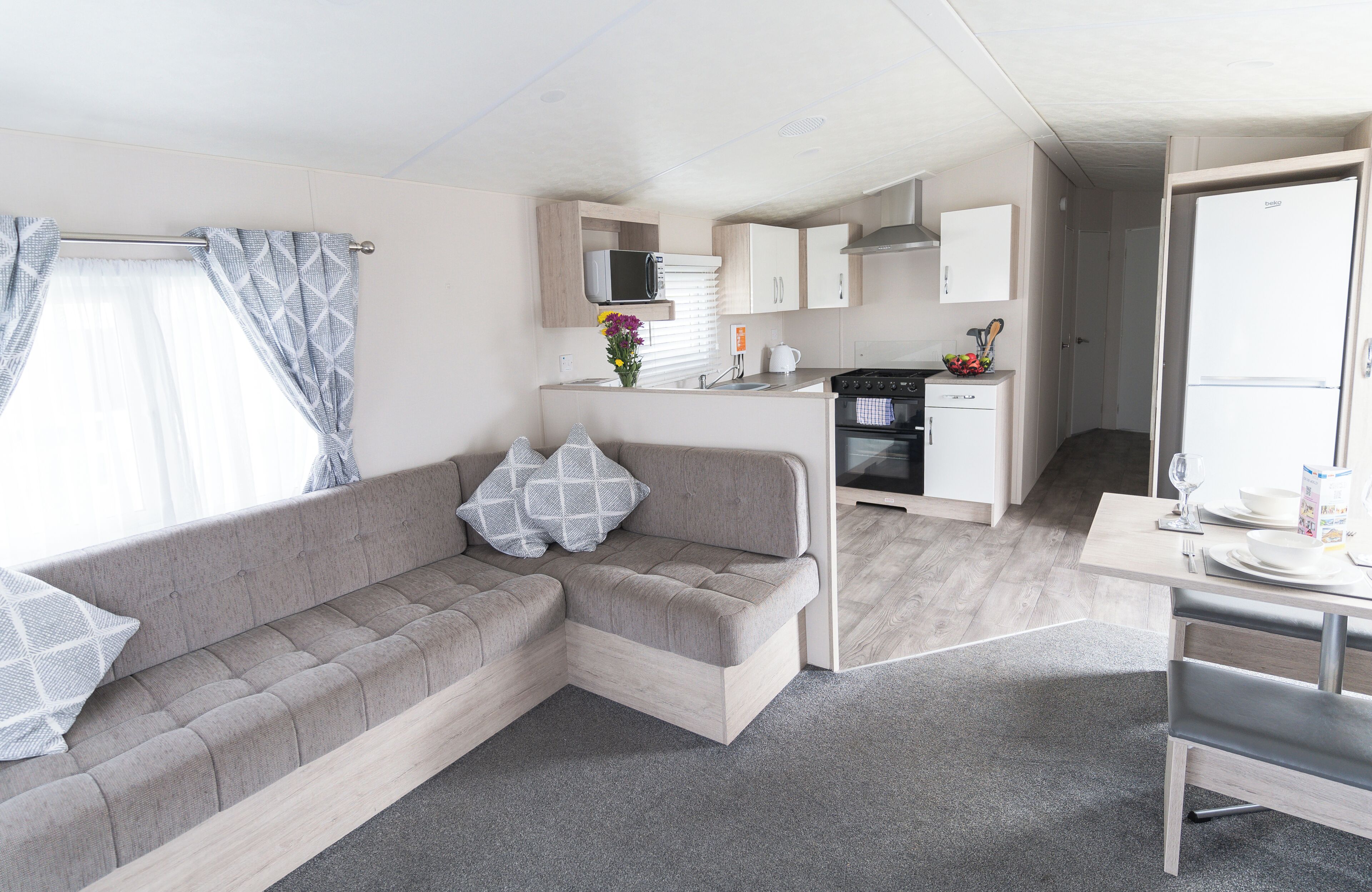 A compact living space with a sofa, kitchenette, and a dining area.