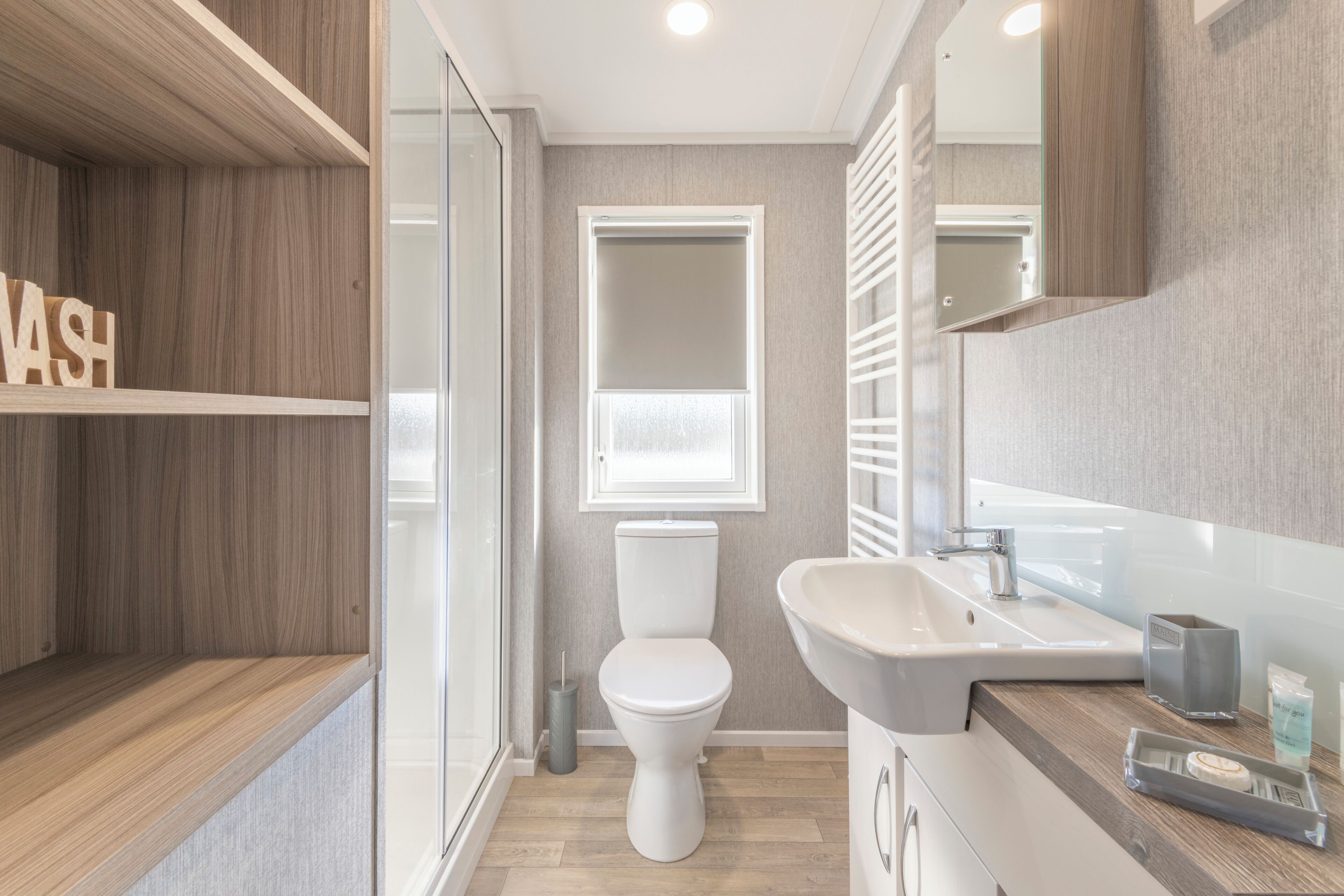 Een moderne badkamer met toilet, wastafel en spiegel.