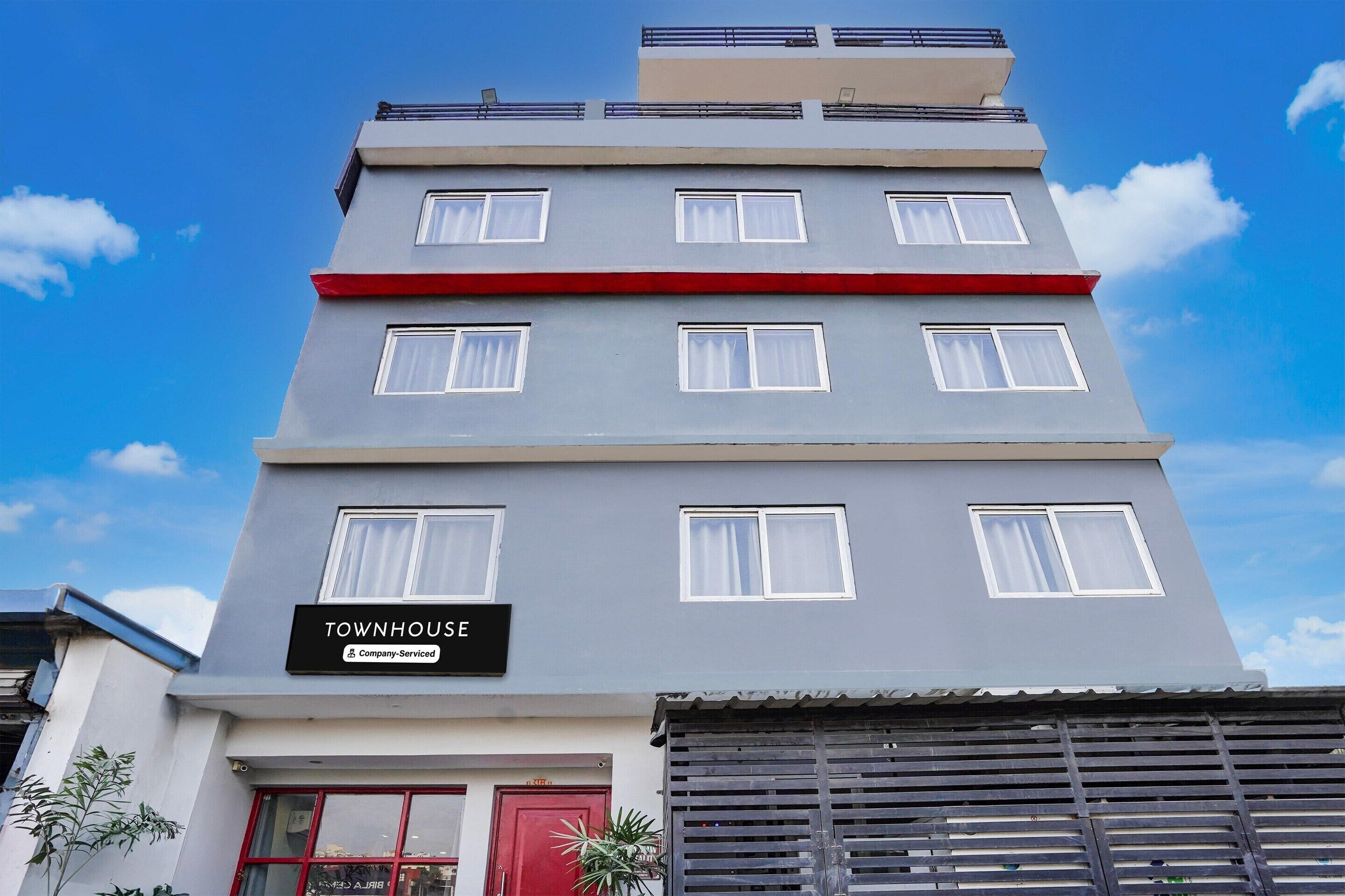 Un immeuble à plusieurs étages sur lequel on peut lire l’inscription « TOWNHOUSE ».