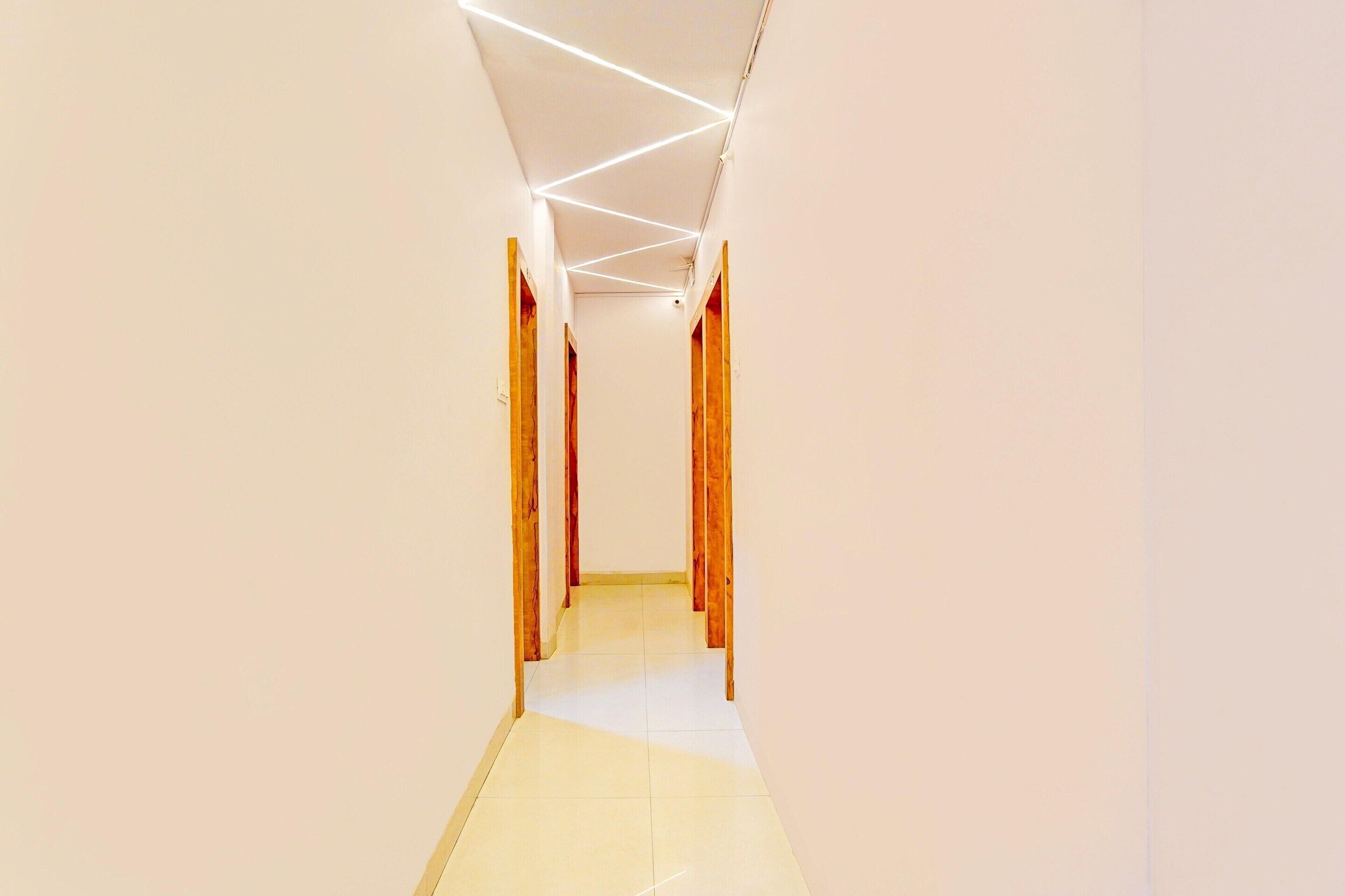 A hallway with a sloped ceiling, wooden door frames, and a tiled floor.