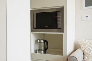 A modern kitchen with a microwave and a coffee maker.