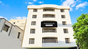 Un immeuble à plusieurs étages sur lequel on peut lire l’inscription : « TOWNHOUSE, entreprise offrant des services ».