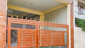 A double wooden gate with decorative metal bars and a green vent. - Saver Doublesuper Hotel O Sudhirpur (Varanasi)