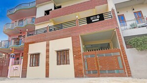 A multi-story hotel with balconies, a sign indicating 'HOTEL O & Company Serviced,' and a gated entrance. - Saver Doublesuper Hotel O Sudhirpur (Varanasi)