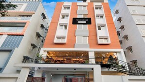 Un edificio de varios pisos con un letrero que dice 'TOWNHOUSE & Company Serviced'.