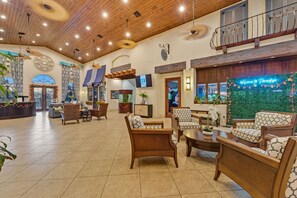 A spacious lobby with wooden ceiling, comfortable seating, a reception desk, and a decorative wall with a welcome sign. - Stylish 4BR, Private Pool, Themed rooms, Sleeps 13 (Four Corners)
