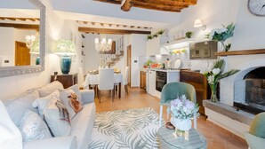 A living room with a sofa, a glass coffee table, and a fireplace. - Apartment in Vorno Near Lucca City Center (Capannori)