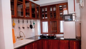 Una cocina con armarios de madera, un lavamanos blanco y una estufa.