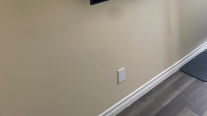 A flat-screen TV mounted on a beige wall.