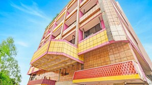 A multi-story building with balconies, a tiled facade, and a clear blue sky. - Hotel O Gajuwaka Near Kurmanpalem (Visakhapatnam)