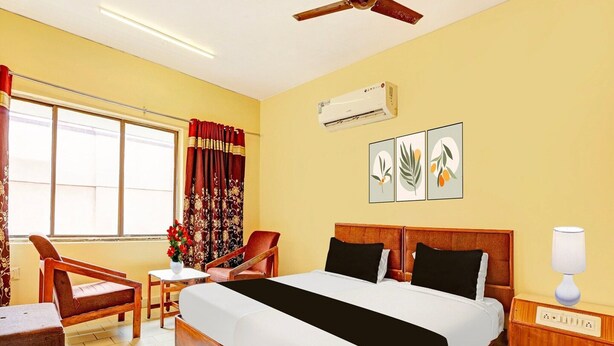 A hotel room with a bed, a desk, a chair, a lamp, and artwork on the wall. - Hotel O Gajuwaka Near Kurmanpalem (Visakhapatnam)
