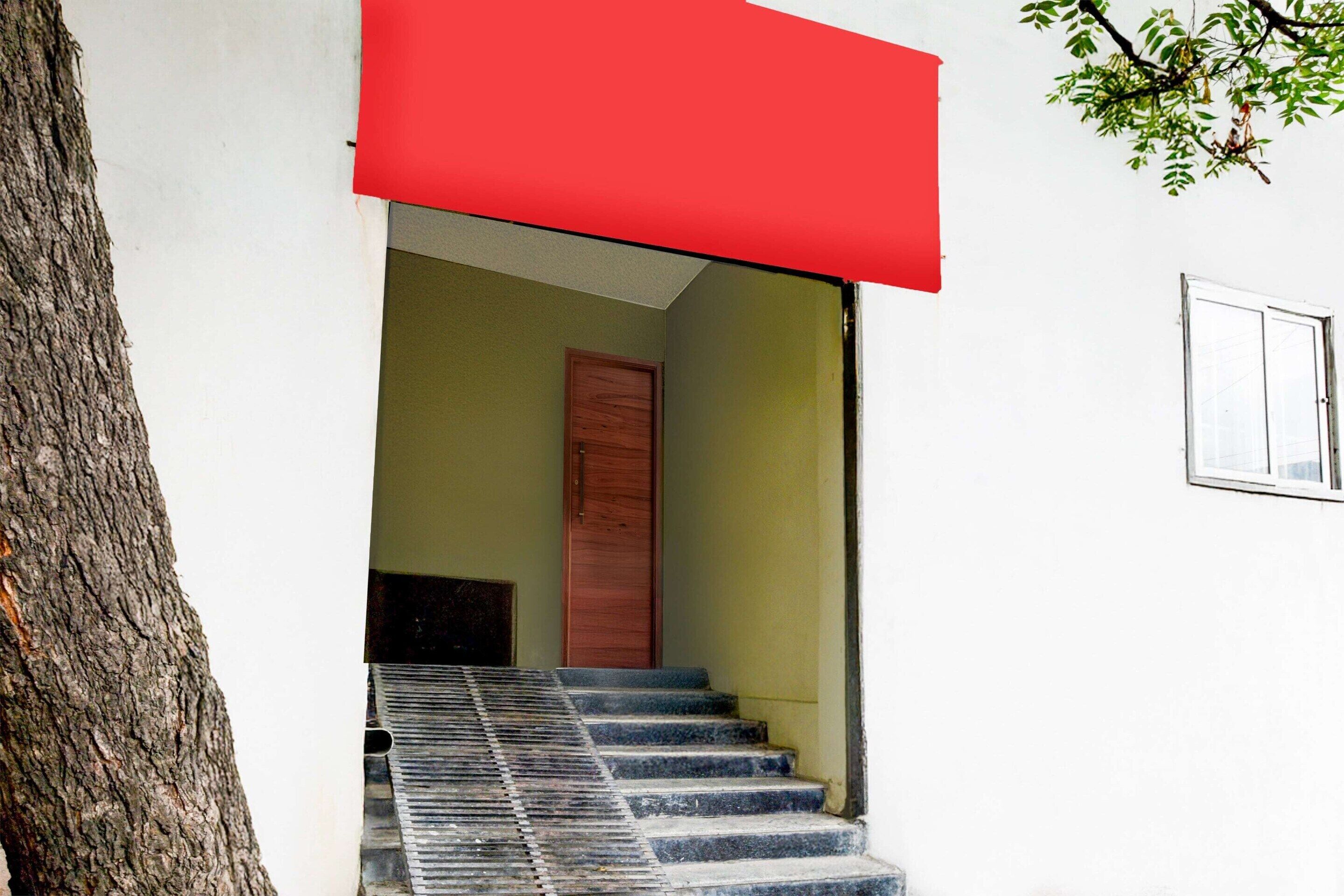 A staircase leading to a door, a tree, and a window on a building.