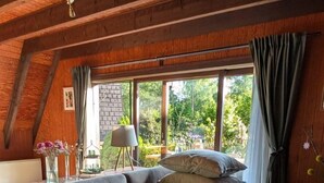 A cozy room with a sofa, pillows, and a window with curtains.