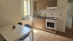 Una cucina compatta con zona pranzo, una sveglia e una finestra.
