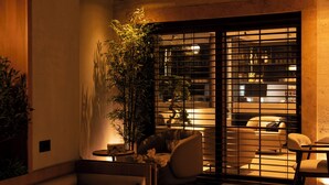 A cozy indoor seating area with a sofa, chairs, a small table, and a potted plant.