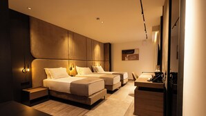 A modern hotel room with a large bed, a desk, and a seating area.