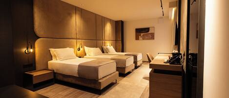 A modern hotel room with a large bed, a desk, and a seating area.