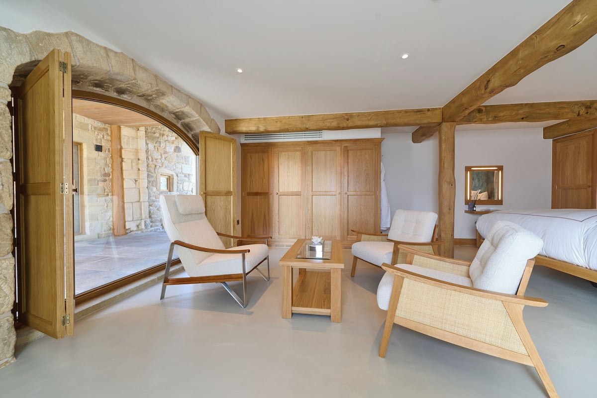 Una habitación con paredes de piedra, muebles de madera y una cama.