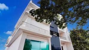Un edificio moderno con un balcón, un amplio ventanal y un cartel que dice 'Collection'.