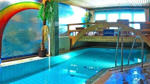 Ein Hallenbad mit klaren blauen Fliesen, einem hölzernen Deck und einem Schild, das die Wassertiefe angibt.