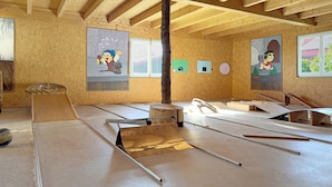Una habitación con vigas de madera, suelo de concreto y diversos materiales de construcción.