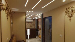 A hallway with a checkered bench, a reception desk, and a door.