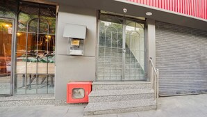 A building with large windows, a red awning, and a closed shutter door. - Saver Single Royal Inn (New Delhi)