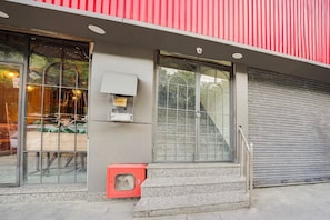 A building with large windows, a red awning, and a closed shutter door. - Saver Single Royal Inn (New Delhi)