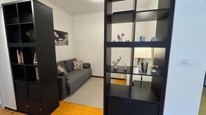 Ein Wohnzimmer mit einer Couch, einem Couchtisch und einem Bücherregal.