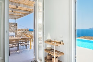Ein modernes Interieur mit Steinwand, Holzmöbeln und Meerblick.